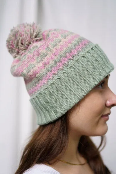 Haus of Namaste Haus of Namaste Handgefertigte Lammwollmütze mit Bommel | Nordische Fair-Isle-Strickmütze | Fair Isle in Rosa und Grün – Produktbild 1 von 3